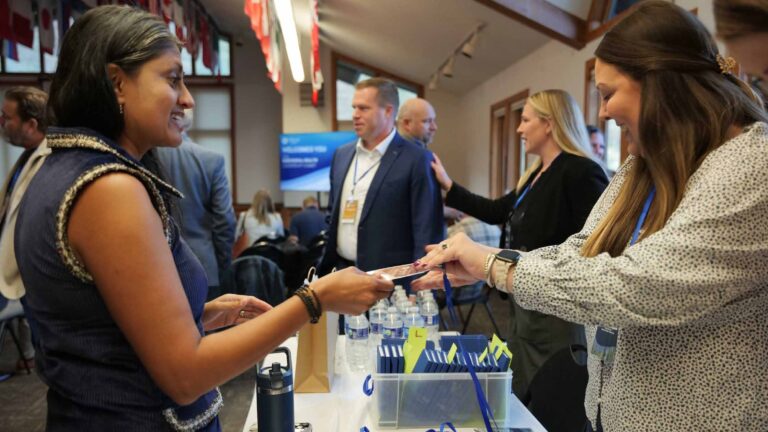 An attendee receives her name badge at the welcome desk.